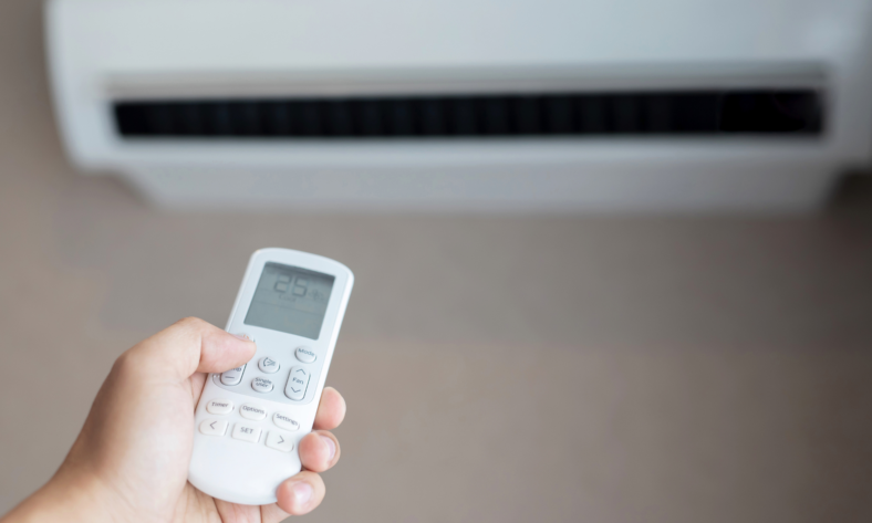 Na zdjęciu widać jak użytkownik próbuje ustawić optymalną dla siebie temperaturę na klimatyzatorze.